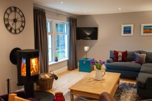 a living room with a couch and a fireplace at Parkside, The Loch Ness Cottage Collection in Inverness