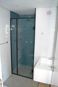 a bathroom with a glass shower and a sink at Flat Jd Paulista Residence in São Paulo