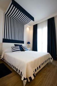a bedroom with a large bed with blue and white pillows at Hotel Nautilus in Cagliari