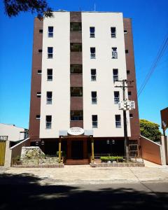 a tall white building with a sign on it at Tulipa Hotel in Foz do Iguaçu