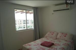 a bedroom with a bed and a window at Aquiraz Riviera in Aquiraz
