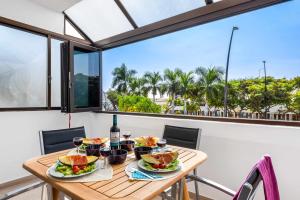 a table with food and wine on a balcony with a view at Las Vistas Cristianos by Welcome Tenerife in Los Cristianos