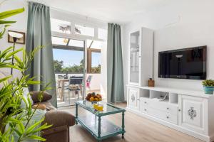 a living room with a couch and a tv at Las Vistas Cristianos by Welcome Tenerife in Los Cristianos