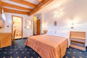 Pokój hotelowy z łóżkiem i łazienką w obiekcie Pineta Pastry Hotel w mieście Rocca Pietore