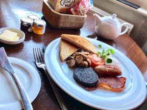 een bord met vlees, brood en champignons bij The Angel Inn B&B in Long Crendon