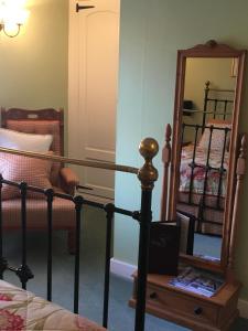 um quarto com um espelho, uma cama e uma escada em The Angel Inn B&B em Long Crendon