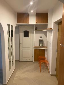 een keuken met een witte deur en een tafel en stoelen bij Apartament przy Stadionie in Tychy