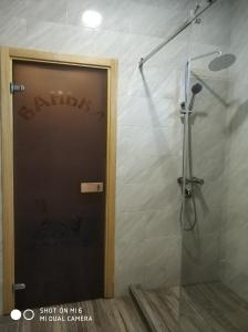 a shower with a glass door in a bathroom at Home and SPA in Kyiv