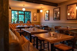 une salle à manger avec des tables et des chaises en bois dans l'établissement The Ring 'O' Bells, à Compton Martin