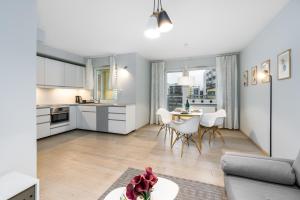 cocina y sala de estar con sofá y mesa en Marcelin Estate Apartments by Renters, en Poznan