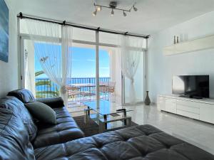 ein Wohnzimmer mit einem Sofa und einem TV in der Unterkunft Tuhillo 2D Seaview Apartments Casasol in Nerja