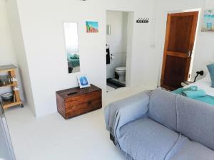 uma sala de estar com um sofá e um espelho em Bokkomblommetjie em Lambertʼs Bay