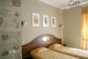2 Betten in einem Zimmer mit Plakaten an der Wand in der Unterkunft Old Vienna in Sankt Petersburg
