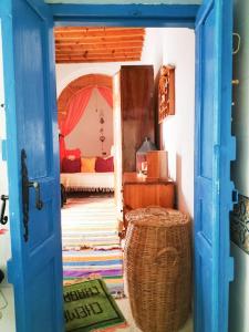 Une porte s'ouvre sur une chambre dotée d'un lit. dans l'établissement Maison d'hôte Chama, à Kairouan