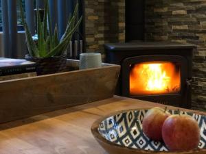 a bowl of apples in front of a fireplace at Dreamwoodz - een droomchalet op de Veluwe in Laag-Soeren
