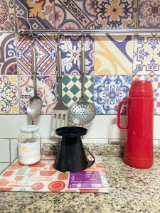 a kitchen counter with utensils on a counter top at Casa Solana - confortável, em rua calma, no centro do Rosa in Imbituba +39 photos