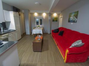 uma sala de estar com um sofá vermelho e uma mesa em Guest House Milicevic em Ljubuski