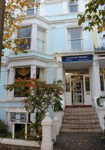 a white building with a staircase in front of it at Llandudno Hostel in Llandudno