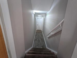 a hallway with a stairway with a white door at Beautiful Spacious Central Flat, Pitlochry in Pitlochry
