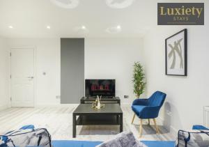a living room with a blue chair and a table at City Centre - Modern Apartment - by Luxiety Stays Serviced Accommodation Southend on Sea - in Southend-on-Sea