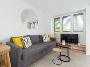 a living room with a gray couch and a table at Bungalow nuevo con jardín y piscina/ Newly renovated Bungalow with private garden and swimming pool in Maspalomas