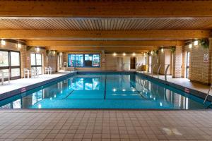 een groot zwembad in een gebouw bij Camping Pods Wood Farm Holiday Park in Charmouth