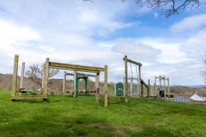 une aire de jeux vide dans un champ herbeux dans l'établissement Camping Pods Wood Farm Holiday Park, à Charmouth