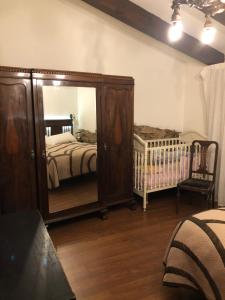 1 dormitorio con espejo grande y cuna en Casa - apartamento rural La Tahona del abuelo, en Plasenzuela