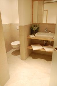 a bathroom with a sink and a toilet and a mirror at Altstadthotel Millipp in Beilngries