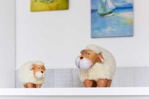 two stuffed sheep sitting on a counter top at Haus Windliese Apartments in Bensersiel