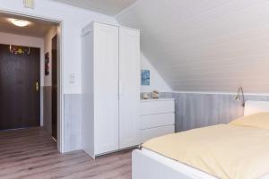 um quarto com uma cama e um armário branco em Haus Windliese Apartments em Bensersiel