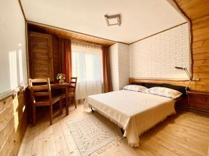 a bedroom with a bed and a desk and a table at Krokus house in Verkhovyna