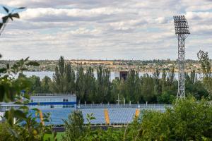 a baseball field with a tower in the background at Apartment near Central Avenue in Mykolaiv