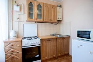 a small kitchen with a stove and a microwave at Apartment near Central Avenue in Mykolaiv