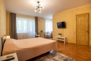a bedroom with a bed and a flat screen tv at Apartment near Central Avenue in Mykolaiv
