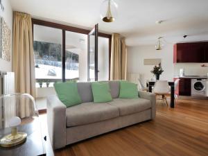 uma sala de estar com um sofá e uma cozinha em Residenze Holiday Park em Ponte di Legno