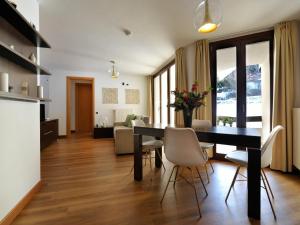 a dining room and living room with a table and chairs at Residenze Holiday Park in Ponte di Legno