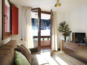 Una sala de estar con un sofá y un televisor. en Residenze Holiday Park by Halldis, en Ponte di Legno