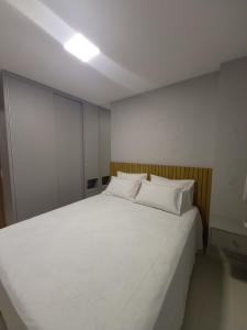 a large white bed with two pillows in a room at Flat a uma quadra da PRAIA e do LARGO DE TAMBAÚ, principal ponto turístico da praia do CABO BRANCO! in João Pessoa