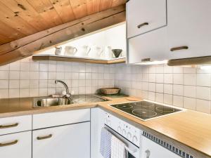 グリンデルワルトにあるApartment Chalet Abendrot-9 by Interhomeの白いキャビネットとシンク付きのキッチン