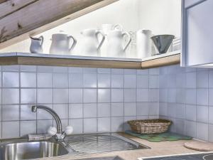 a kitchen sink with cups and dishes on a shelf at Apartment Chalet Abendrot apARTments-9 by Interhome in Grindelwald +16 photos