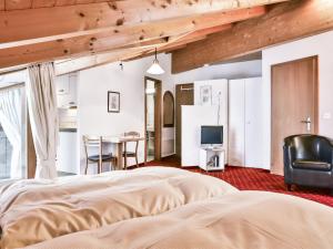 a bedroom with a bed and a television and a table at Apartment Chalet Abendrot apARTments-9 by Interhome in Grindelwald