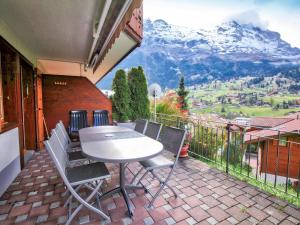 una mesa y sillas en un balcón con una montaña en Apartment Chalet Cortina by Interhome, en Grindelwald
