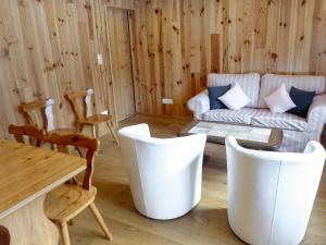 ein Wohnzimmer mit einem Sofa, einem Tisch und Stühlen in der Unterkunft Apartment Chalet Anna by Interhome in Grindelwald