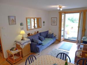 ein Wohnzimmer mit einem blauen Sofa und einem Tisch in der Unterkunft Apartment Sierra Vista by Interhome in Grächen