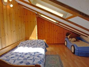 ein Schlafzimmer mit einem Bett und einem Auto darin in der Unterkunft Apartment Museum by Interhome in Grächen