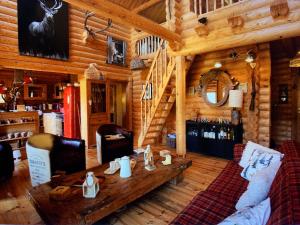 a living room with a table in a log cabin at Chalet luxueux SAUNA WIFI in Roubion