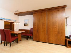 a dining room with a table and red chairs at Apartment Ringstrasse - Utoring-14 by Interhome in Leukerbad