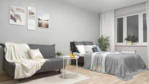 a living room with a bed and a couch at Nikhouse apartment Krasniy put' in Omsk