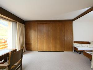 a room with wood paneling and a bed and a window at Apartment Ringstrasse Apt 412 by Interhome in Leukerbad